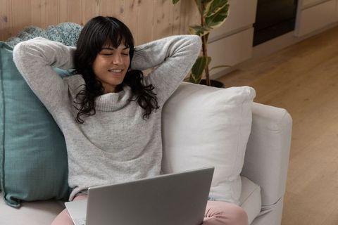 Woman Relaxing with Laptop on Couch in Modern Living Room
