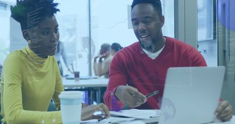 Coworkers collaborating on coding project in office environment