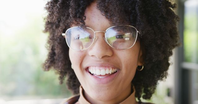 Portrait of happy african american teenager girl wearing glasses, looking at camera and smiling. Spending quality time, lifestyle and adolescence concept.