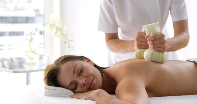 Relaxed Woman Receiving Herbal Massage at Wellness Spa - Download Free Stock Images Pikwizard.com