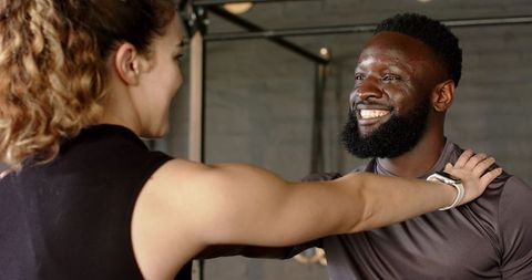 Diverse Trainer Guiding Gym Workout with Client Motivation