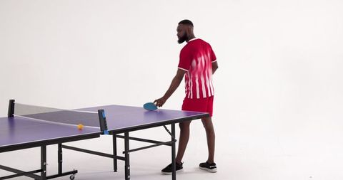African American Man Playing Ping-Pong in Modern Studio