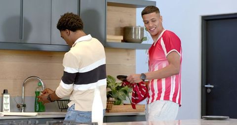 Diverse Friends Washing Dishes Together in Contemporary Kitchen
