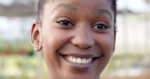 African American Woman Smiling Brightly Inside Greenhouse