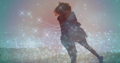 Backlit silhouette couple embracing on beach with sparkling bokeh and dreamy sunset