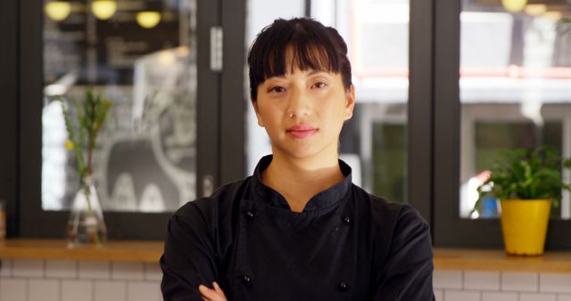 Confident Female Chef in Black Uniform Arms Crossed in Kitchen - Download Free Stock Images Pikwizard.com