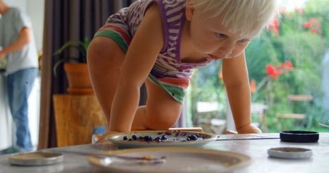 Curious Toddler Exploring Table at Home