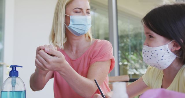 Mother and Daughter Wearing Masks Using Hand Sanitizer - Download Free Stock Images Pikwizard.com