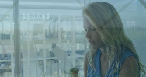 Caucasian Businesswoman Engaged with Digital Data Interface in Modern Office