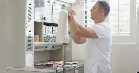 Technician adjusting prosthetic component in modern lab