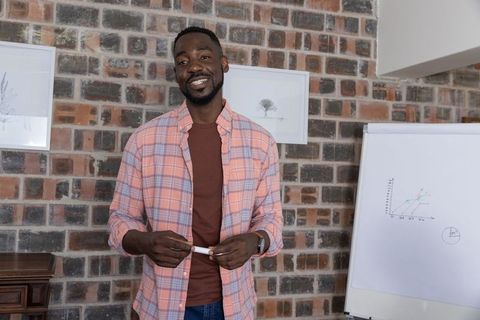 Confident Professional Presenting Line Graph in Modern Office