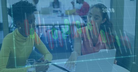 Colleagues analyzing stock data on laptop in modern office environment