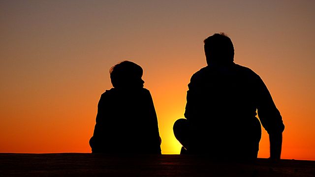 Father and Son Sitting Silhouetted Against Sunset - Download Free Stock Photos Pikwizard.com