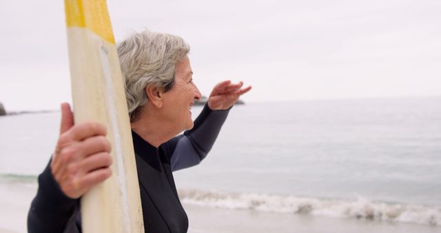 Senior Woman Holding Surfboard at Beach Looking to Horizon - Download Free Stock Images Pikwizard.com