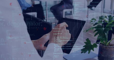 Hands tapping tablet with code overlay in modern office collaboration, data visualization