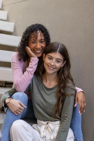 Joyful Female Friends Smiling on Urban Staircase