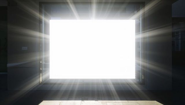 Rectangular light portal emitting radiant beams in dark gallery entrance with symmetry