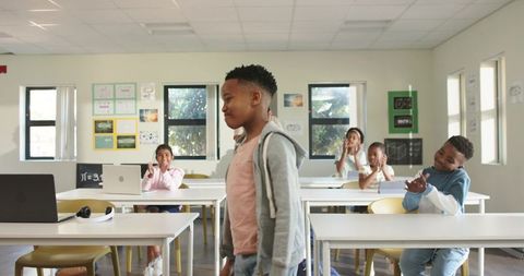 African American Boy Receiving Applause From Classmates in Bright Modern Classroom