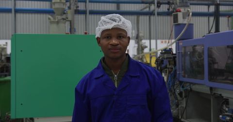 Factory Worker Wearing Hair Net Smiling at Machinery - Download Free Stock Images Pikwizard.com