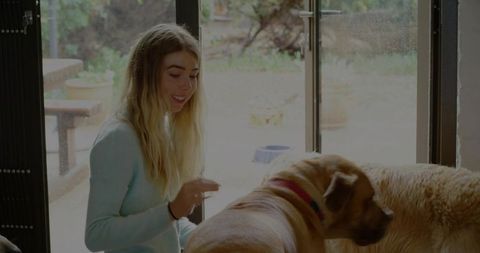 Young Woman Enjoying Quality Time with Dogs at Home