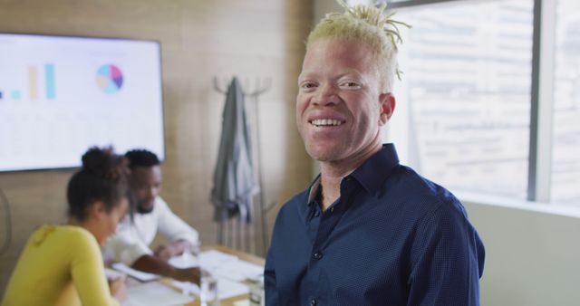 Portrait of happy albino african american businessman with tablet in creative office - Download Free Stock Photos Pikwizard.com