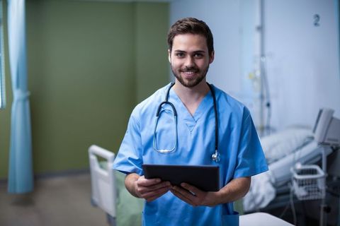 Doctor holding tablet using technology in hospital ward
