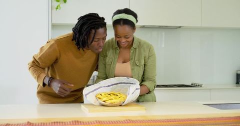 African american couple unveiling freshly baked lattice fruit pie at modern kitchen island