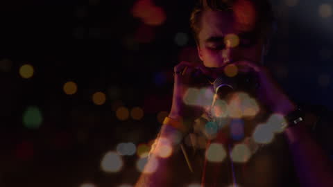 Harmonica Player Blended with Bokeh Lights in Dimly Lit Ambiance