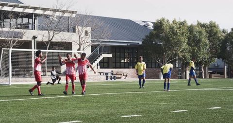 Diverse Soccer Team Celebrating Goal on Sunny Field