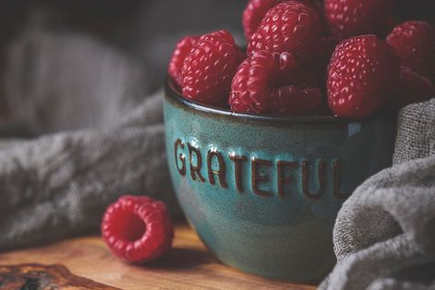 Grateful Ceramic Bowl Overflowing with Fresh Raspberries on Rustic Wooden Board