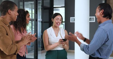 Diverse colleagues celebrating achievements in modern office