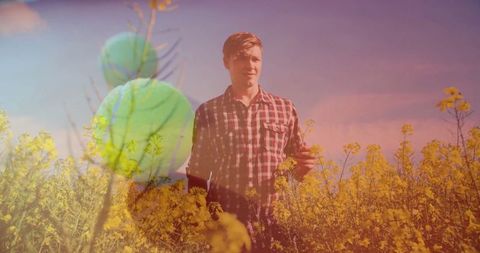 Man standing in blooming field during golden hour