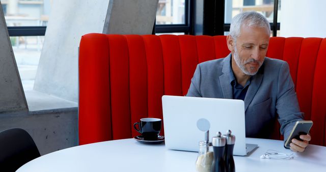 Businessman Working on Laptop and Smartphone in Modern Cafe - Download Free Stock Images Pikwizard.com