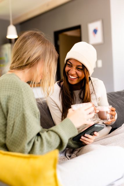 Happy Teenage Friends Using Smartphone and Drinking Cocoa at Home - Download Free Stock Images Pikwizard.com