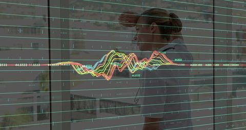 Doctor analyzing medical data with futuristic graph overlay in hospital corridor