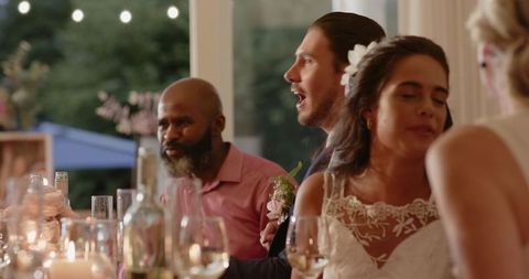 Guests enthusiastically socializing at wedding reception dinner