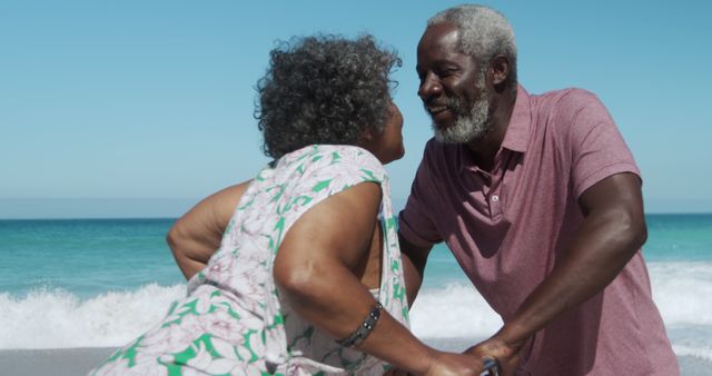 Happy african american senior couple holding hands on beach by seaside with copy space. Retirement, lifestyle, vacation, summer, happiness, wellbeing concept, unaltered.