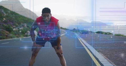 Young black runner pausing on coastal road tracking workout with hud overlay and smartwatch