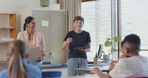 Teacher supporting student presentation using tablet in classroom