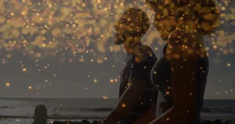 Couple Walking on Beach at Golden Hour with Sparkling Light
