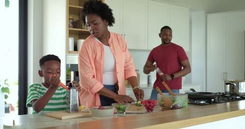African American family preparing healthy meal together in bright modern kitchen oasis