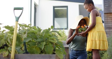 Mother and Daughter Planting Flowers in Backyard Garden