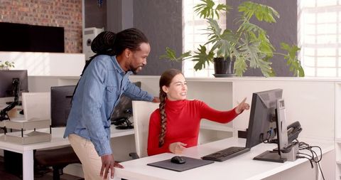 Colleagues Collaborating on Project at Office Desk