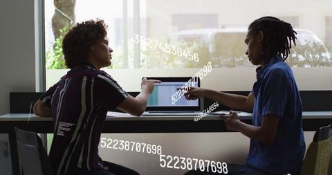 Collaborative Colleagues Analyzing Data with Laptop in Modern Café