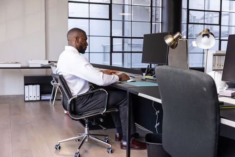 Professional man working at desk with dual monitors in modern office