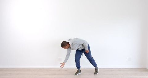 Man Stretching Downward in Minimalist Home Environment - Download Free Stock Images Pikwizard.com