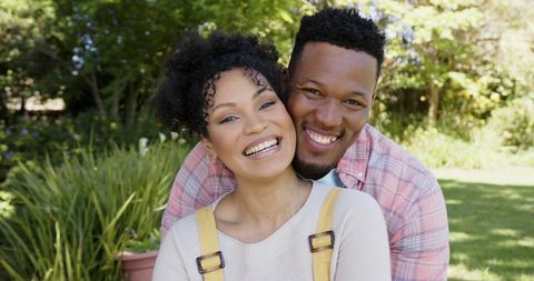 Joyful african american couple embracing in garden