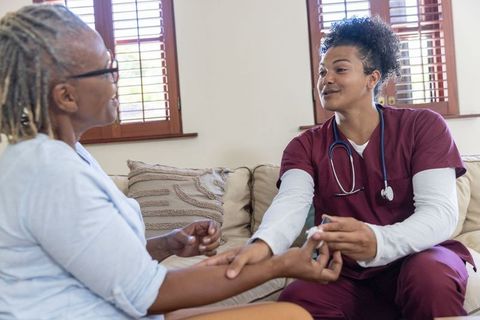 Male nurse checking blood glucose of senior african american woman during homecare visit