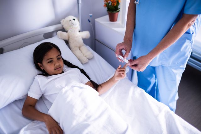 Female Doctor Checking Blood Sugar Level of Young Patient in Hospital Bed - Download Free Stock Photos Pikwizard.com