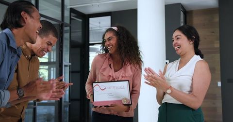 Diverse office team celebrating employee award achievement